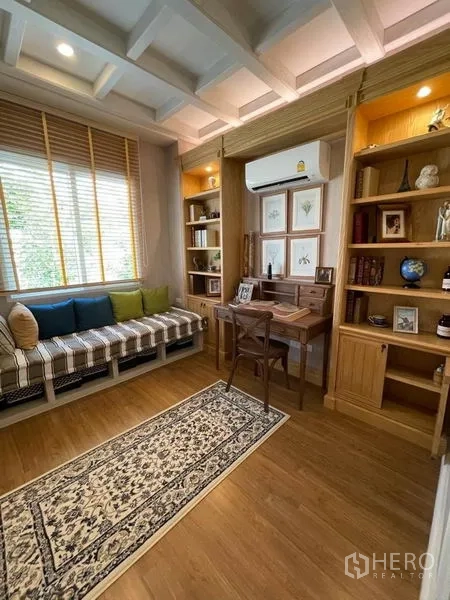 Detached House for rent or sale in Pathum Thani - Study room with built-in wooden bookshelves, desk and window bench.