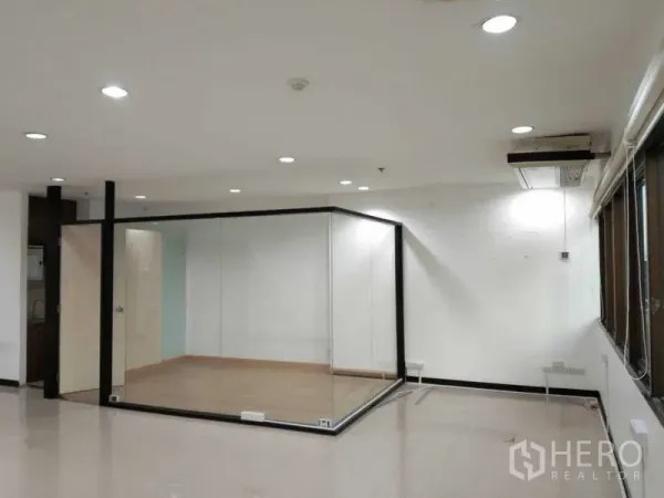 Office Space for rent in Watthana, Bangkok - Spacious office featuring a glass-walled meeting room and a window wall with city views near Ekkamai.
