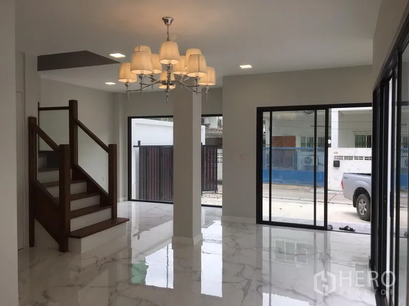 บ้าน ให้เช่าในKhlong Toei, Bangkok - โถงรับแขกชั้นล่างสว่าง พื้นกระเบื้องลายหินอ่อน ประตูกระจกบานเลื่อน และบันไดไม้