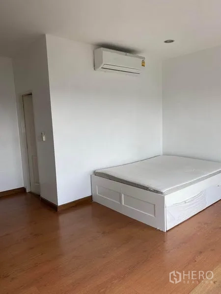 ทาวน์เฮาส์ ให้เช่าในLat Phrao, Bangkok - ห้องนอนที่สามพร้อมเครื่องปรับอากาศติดผนังและเตียงแพลตฟอร์ม พื้นไม้