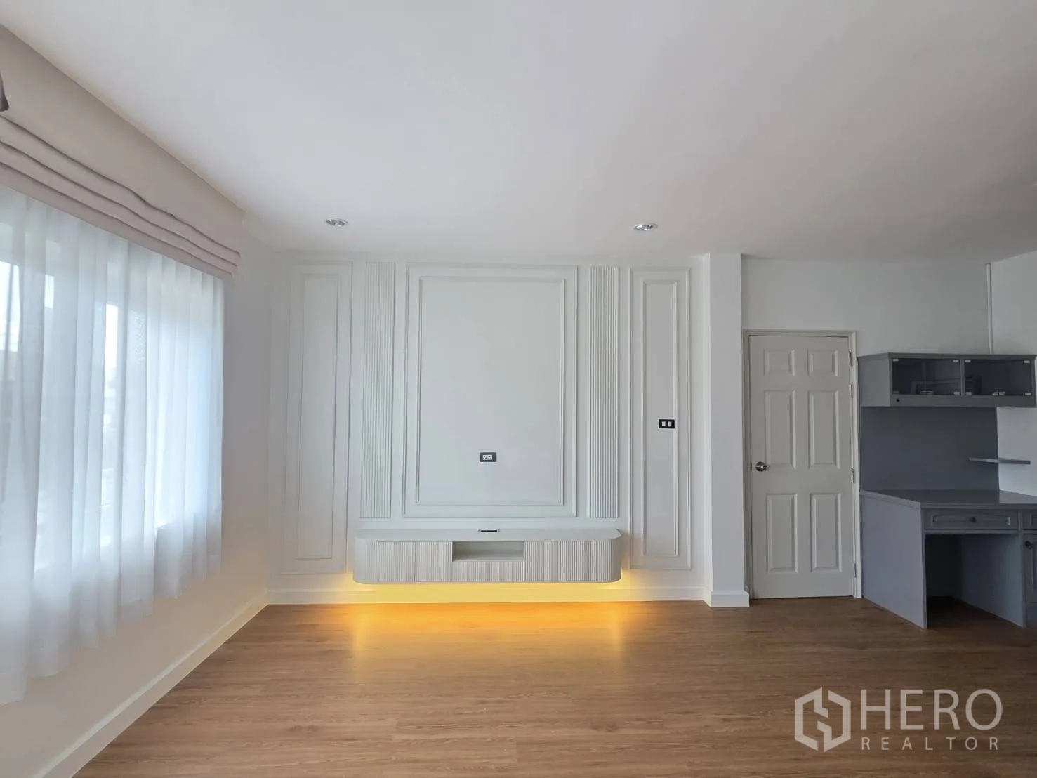Detached House for sale in Lam Luk Ka, Pathum Thani - Bedroom TV wall with decorative paneling and floating console with warm lighting.