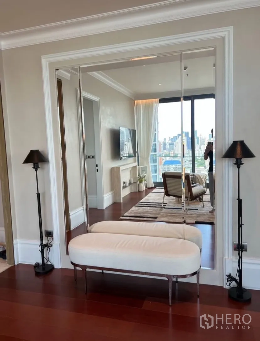 公寓 出租或出售在Watthana, Bangkok - 玄关带镜面墙与长椅，映出客厅景致。