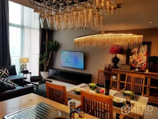 Condominium for sale in Sathon, Bangkok - Stylish living and dining area with statement chandelier, TV wall and floor-to-ceiling windows at The Empire Place Sathorn.