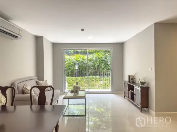 คอนโด ขายในWatthana, Bangkok - ห้องนั่งเล่นพร้อมประตูกระจกบานเลื่อนมองเห็นสวนเขียวร่มรื่น