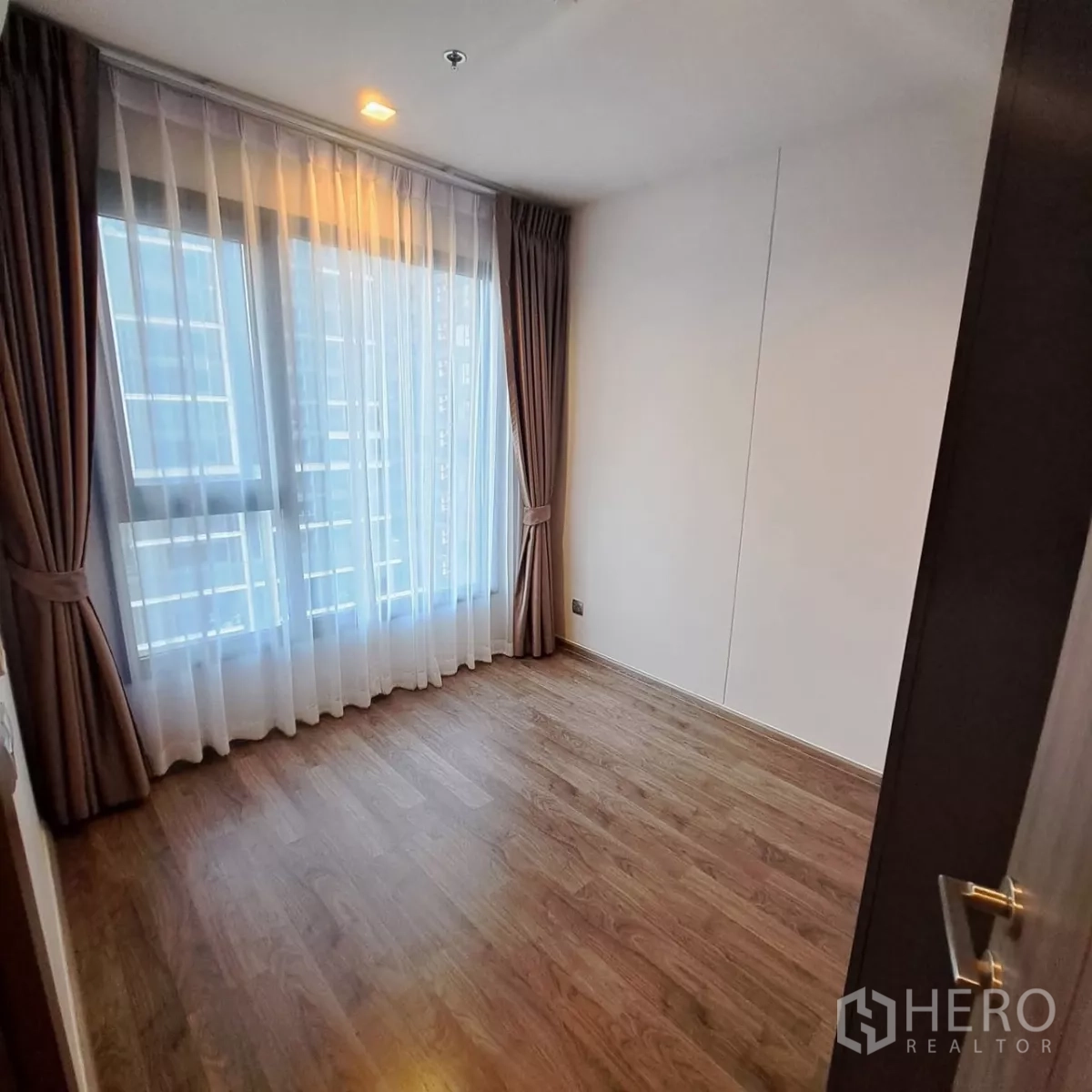 คอนโด ให้เช่าในChatuchak, Bangkok - ห้องนอนที่สองโล่ง ปูพื้นไม้ พร้อมหน้าต่างสูงจรดเพดานและผ้าม่าน