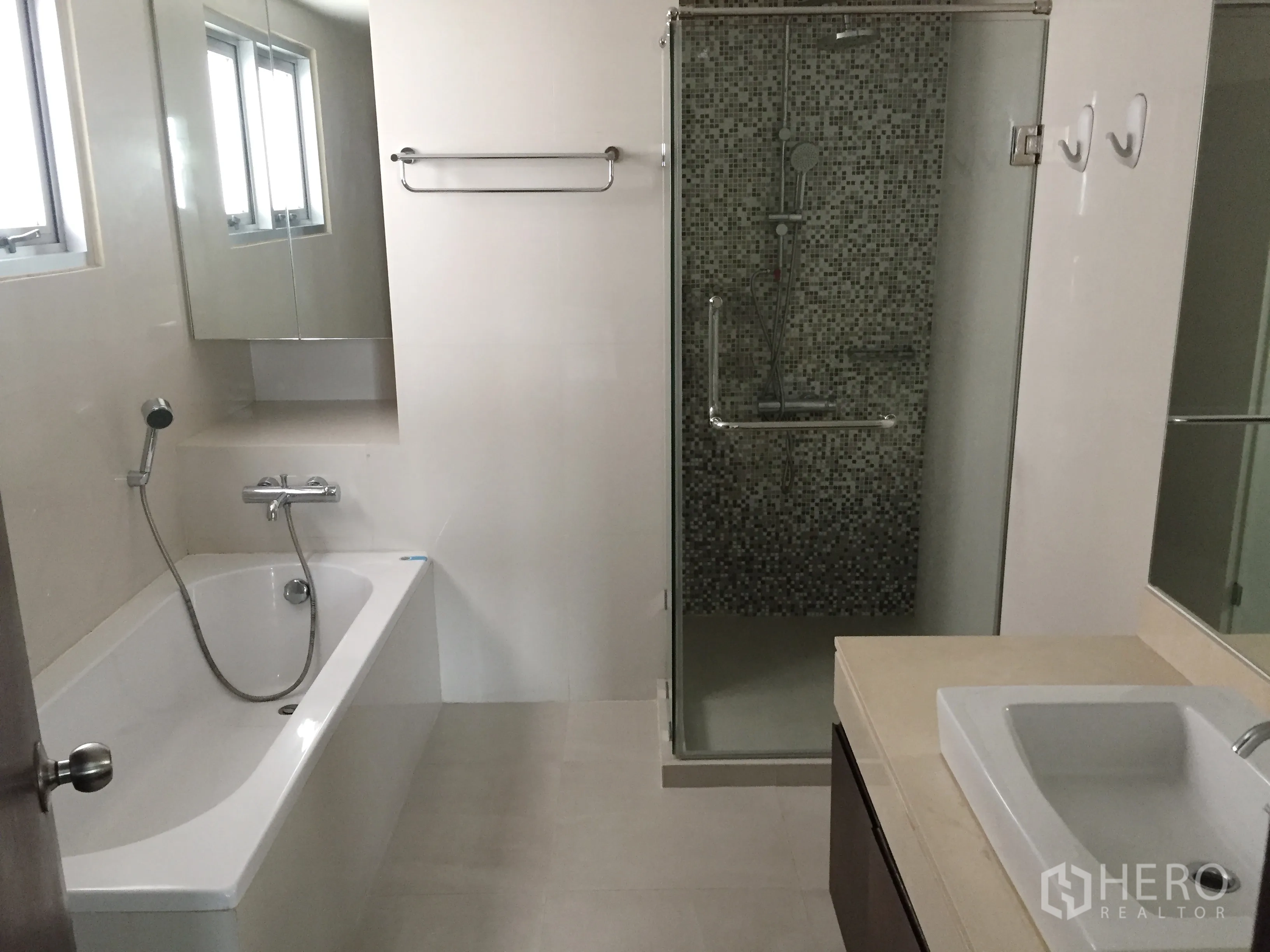 คอนโด ให้เช่าในPathum Wan, Bangkok - ห้องน้ำสมัยใหม่พร้อมอ่างอาบน้ำ ห้องอาบน้ำกระจกลายโมเสก และเคาน์เตอร์อ่างล้างหน้าพร้อมกระจก