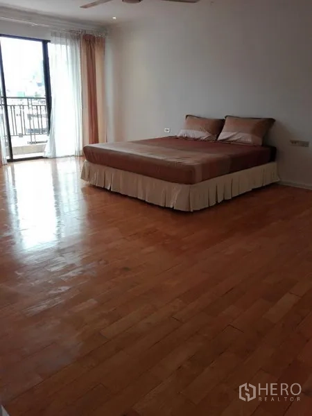 คอนโด ให้เช่าในKhlong Toei, Bangkok - ห้องนอนมาสเตอร์กว้าง พื้นไม้ เตียงนอน และประตูระเบียงพร้อมผ้าม่านโปร่ง