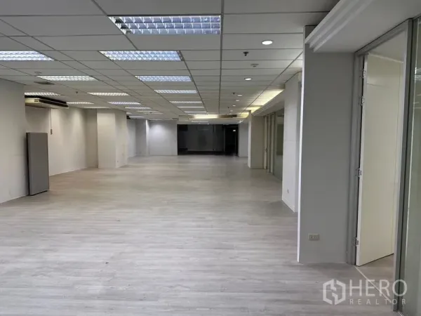 办公空间 出租在Din Daeng, Bangkok - 开放式办公楼层，浅木色地板和荧光灯吊顶。