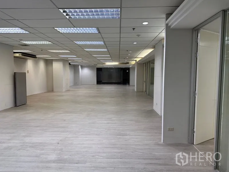 办公空间 出租在Din Daeng, Bangkok - 开放式办公楼层，浅木色地板和荧光灯吊顶。