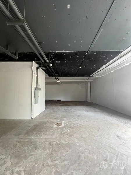 พื้นที่ขายปลีก ให้เช่า - พื้นที่ค้าปลีกสภาพเปลือก เพดานเปิดสีดำ พื้นคอนกรีตและผนังสีขาว พร้อมตกแต่งต่อได้ทันที