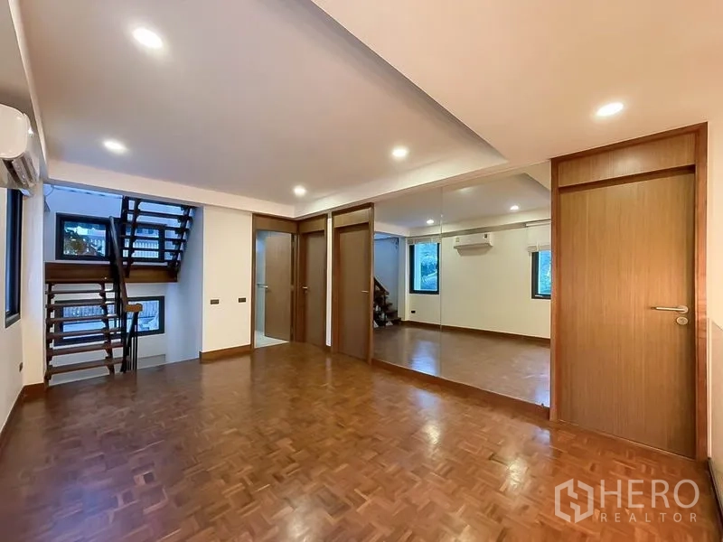 ทาวน์เฮาส์ ให้เช่าในKhlong Toei, Bangkok - ห้องอเนกประสงค์ชั้นบน ผนังกระจกเงา พื้นไม้ และบันไดเชื่อม