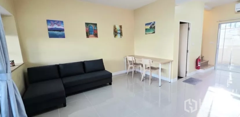 Townhouse for rent in Bang Bo, Samut Prakan - Bright living and dining area with sofa, table and glossy tiled floors.