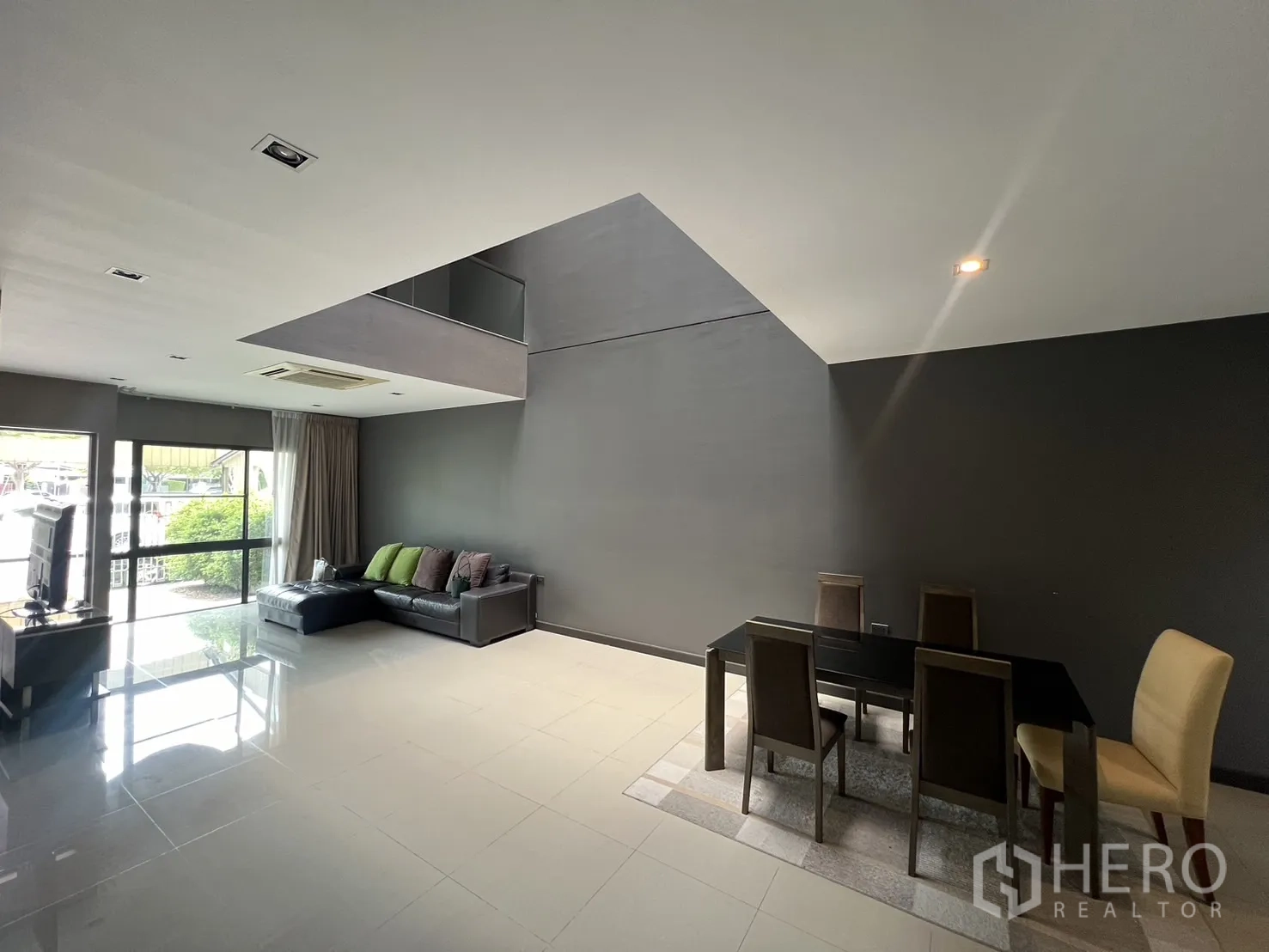 联排别墅 出租在Lat Phrao, Bangkok - 開放式客餐廳，挑空中庭與拋光地磚，推拉玻璃門相連。