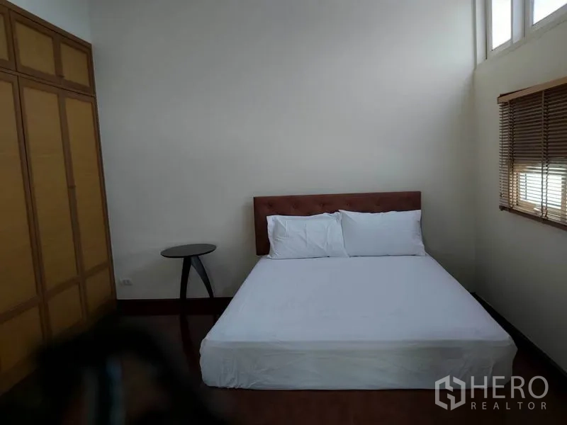 公寓 出租在Watthana, Bangkok - 卧室配大床、嵌入式衣柜与带百叶的转角窗。