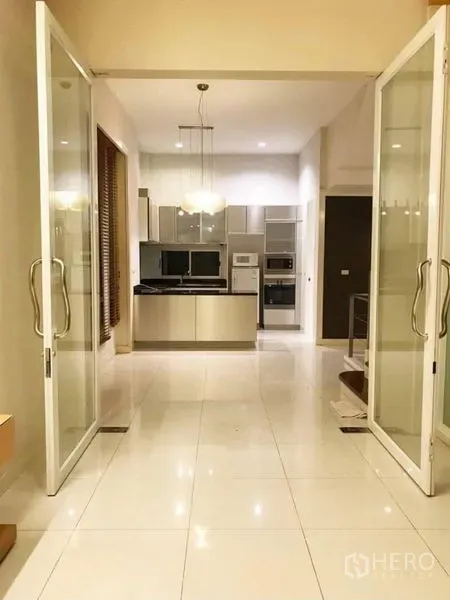 联排别墅 出租在Wang Thonglang, Bangkok - 开放式餐区，通过大玻璃门通往厨房，配吊灯。