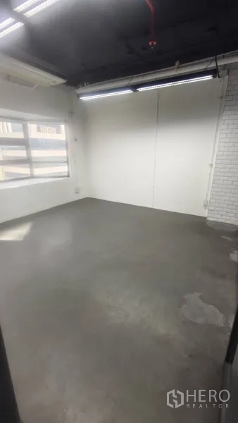 办公空间 出租在Pathum Wan, Bangkok - 角落办公间，水泥地、白色砖墙点缀与采光窗。