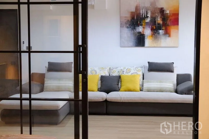 公寓 出租在Bang Rak, Bangkok - 通过黑框推拉玻璃门看到的客厅。