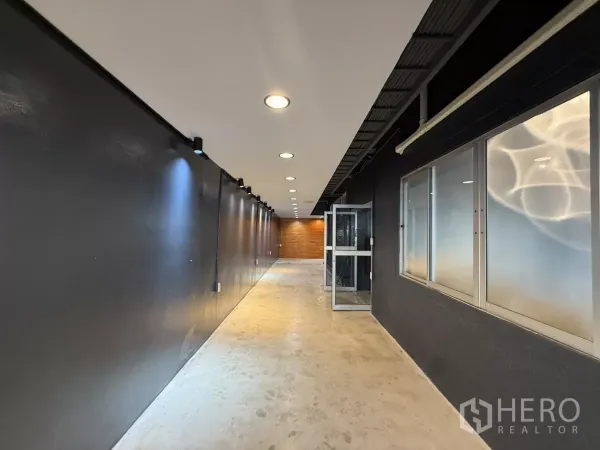 Office Space for rent in Wang Thonglang, Bangkok - Long corridor with track lights, frosted windows and concrete flooring.