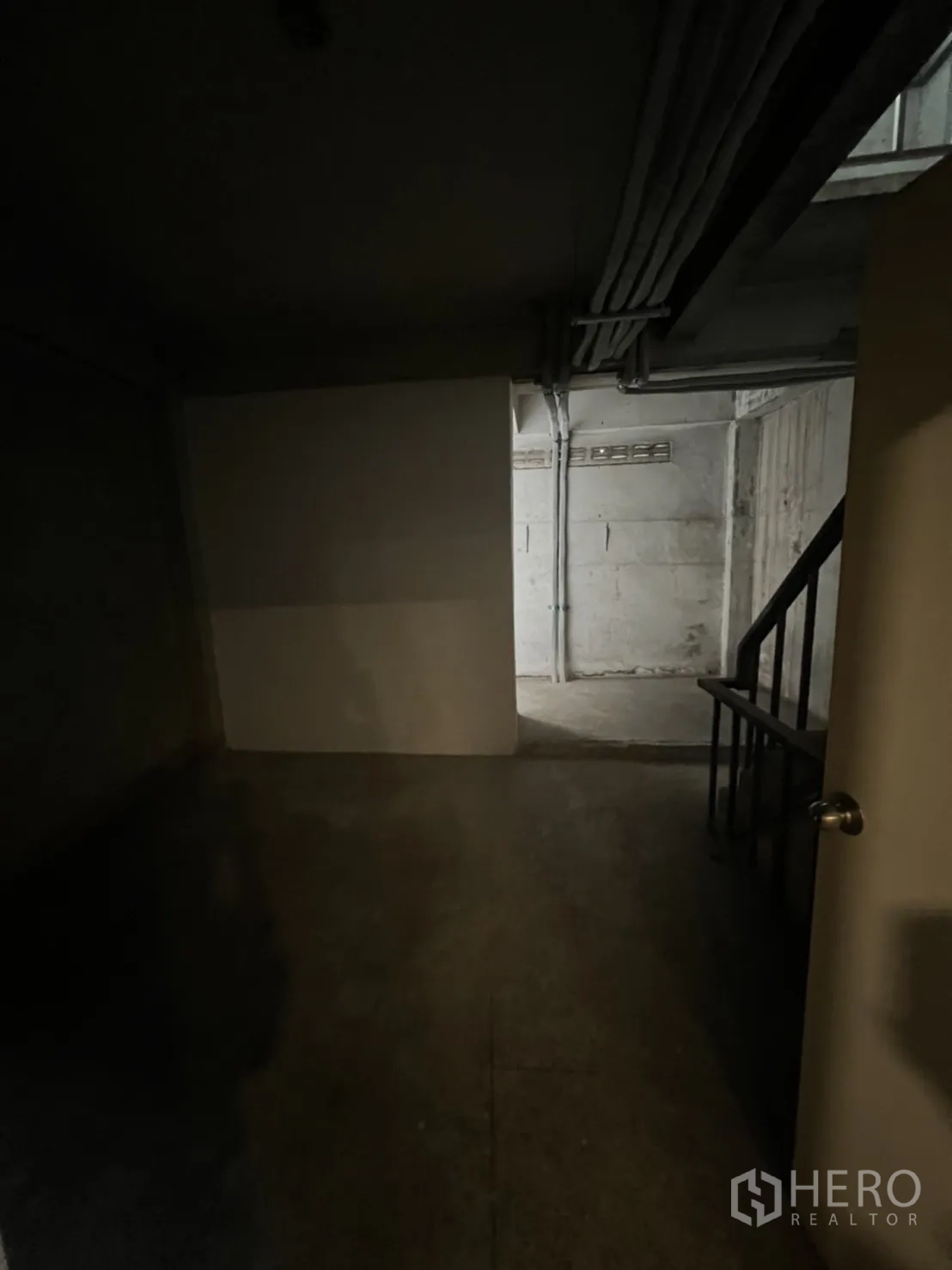 店屋 出租在Phra Khanong, Bangkok - 地库储藏空间，水泥墙面与楼梯出入口。