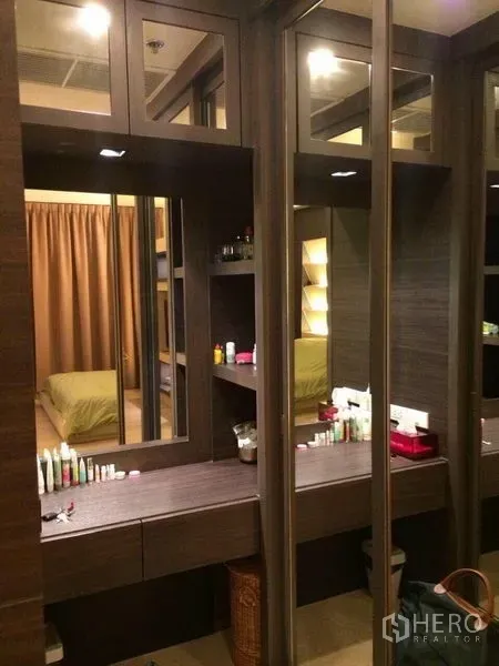 Condominium for rent in Watthana, Bangkok - Walk-in wardrobe with mirrored panels and a built-in vanity in a modern condo.