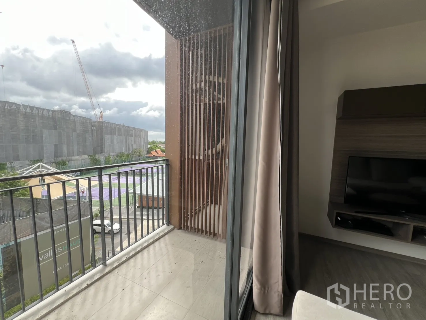 公寓 for rent in Watthana, Bangkok - 从推拉门望向带栏杆的阳台与城市景观。