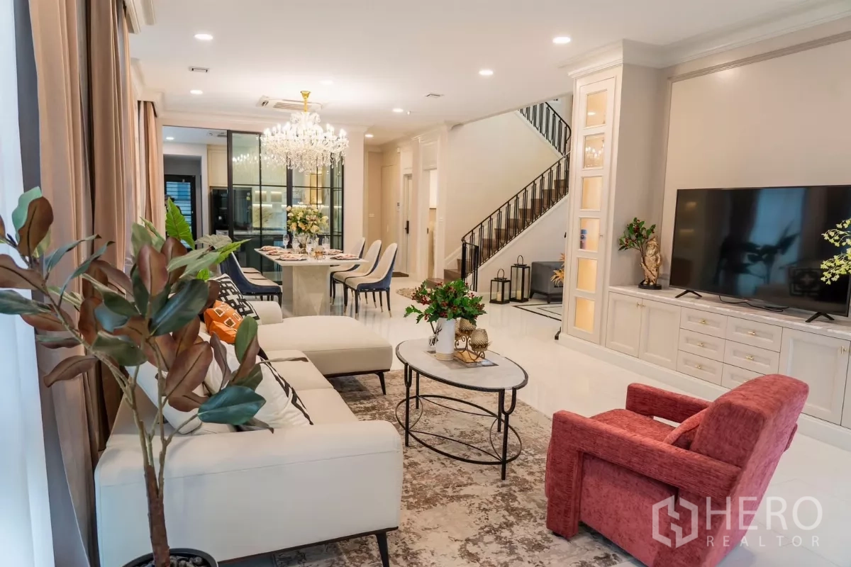 Detached House for rent in Saphan Sung, Bangkok - Bright lounge with TV wall, built-in cabinetry, and staircase with iron balustrade.