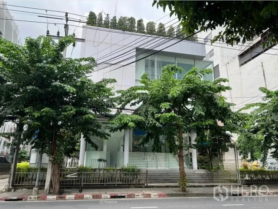 Office Space for rent in Bang Rak, Bangkok - Modern low-rise office building with glass façade and street trees in Bang Rak, Bangkok.