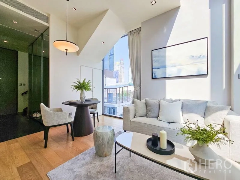 Condominium for rent - Sunlit living and dining area with pendant light, neutral sofa, and wood floors.