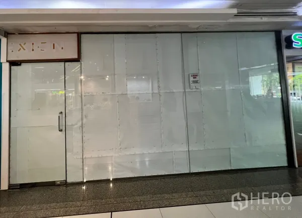 Retail Space for rent - Vacant retail shop with full-height frosted glass storefront and single glass door along an indoor mall corridor near BTS Asok.