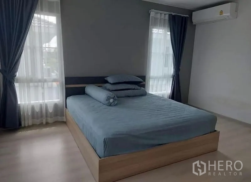 Detached House for rent in Bang Bo, Samut Prakan - Master bedroom with large windows, blackout drapes and an air-conditioning unit.