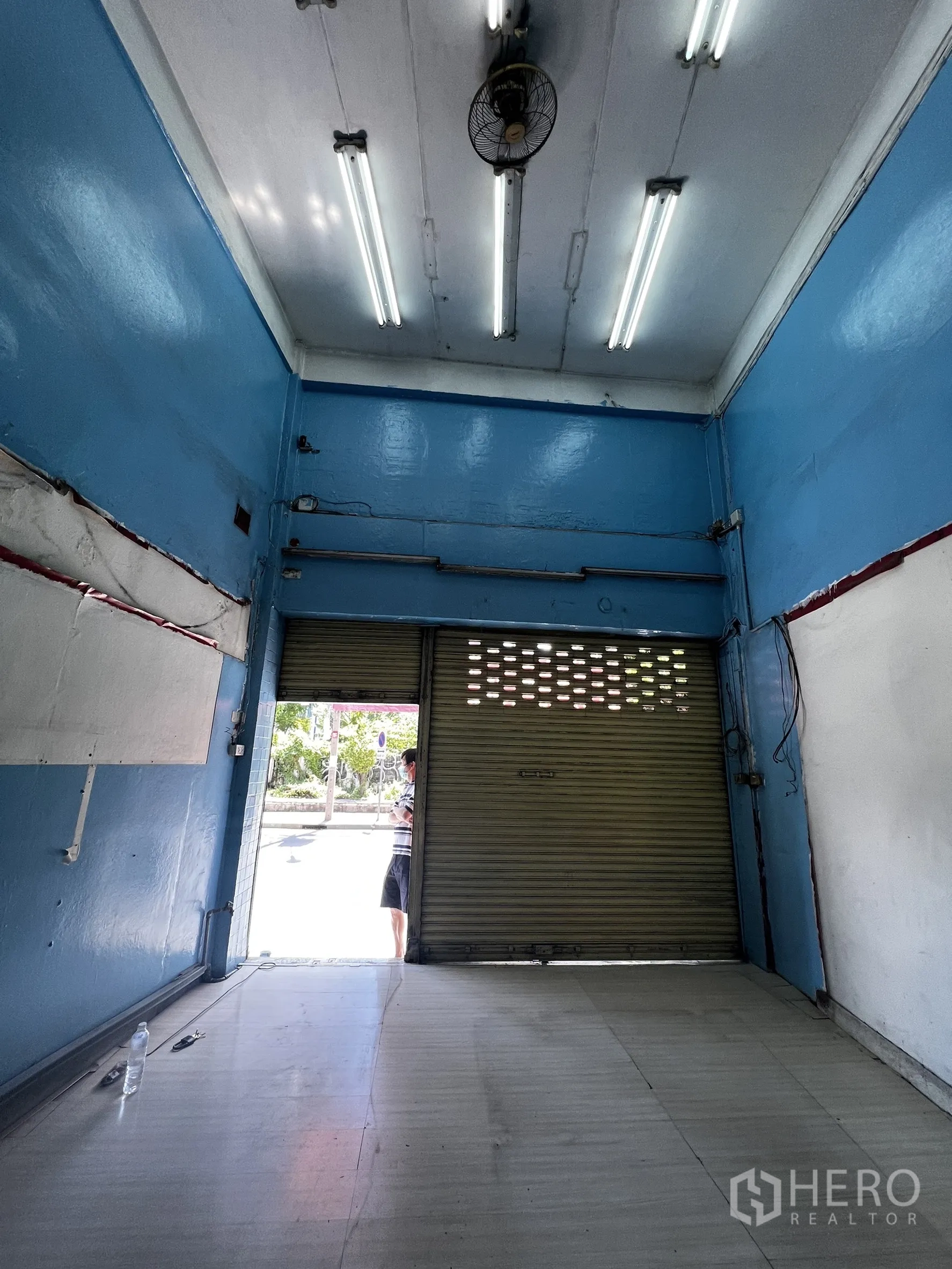 店屋 出租在Watthana, Bangkok - 一层临街商铺空间，卷闸门与日光灯。