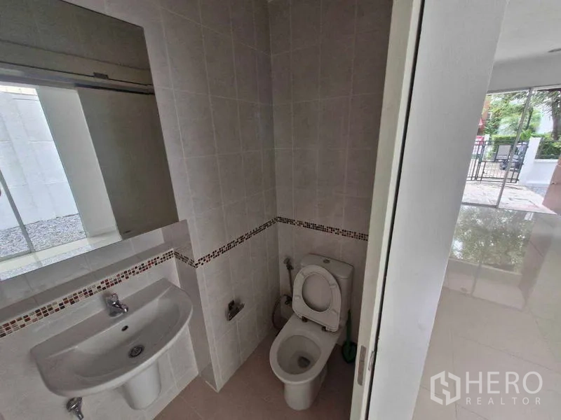 独立式住宅 出售在Rat Burana, Bangkok - 铺砖的客卫，含洗手盆、镜子与坐便器