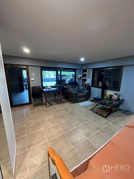 Detached House for sale in Bang Bua Thong, Nonthaburi - Lounge view with large windows, desk and recliner looking out to the terrace.