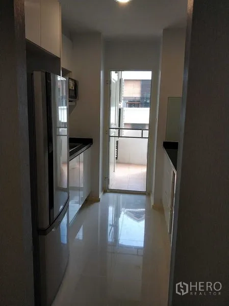 คอนโด ให้เช่าในKhlong Toei, Bangkok - ครัวสไตล์แกลลี ตู้เงามัน เคาน์เตอร์สีดำ เชื่อมต่อระเบียงเล็ก