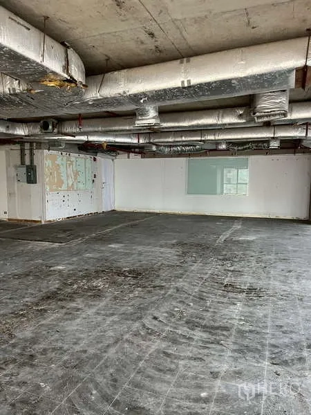 Office Space for rent - Unfurnished office interior with exposed ducting, white walls and concrete floor, ready for tenant fit-out.