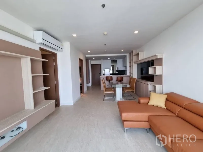 คอนโด ให้เช่าในWatthana, Bangkok - โซนนั่งเล่นเปิดโล่งเชื่อมระเบียง พร้อมชั้นวางบิลต์อินและโซฟาหนังทรง L