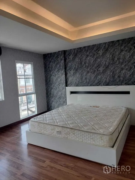 ทาวน์เฮาส์ ให้เช่าในBueng Kum, Bangkok - ห้องนอนมุมบ้าน หน้าต่างกว้าง ฝ้าหลุมซ่อนไฟ และเตียงสีขาว