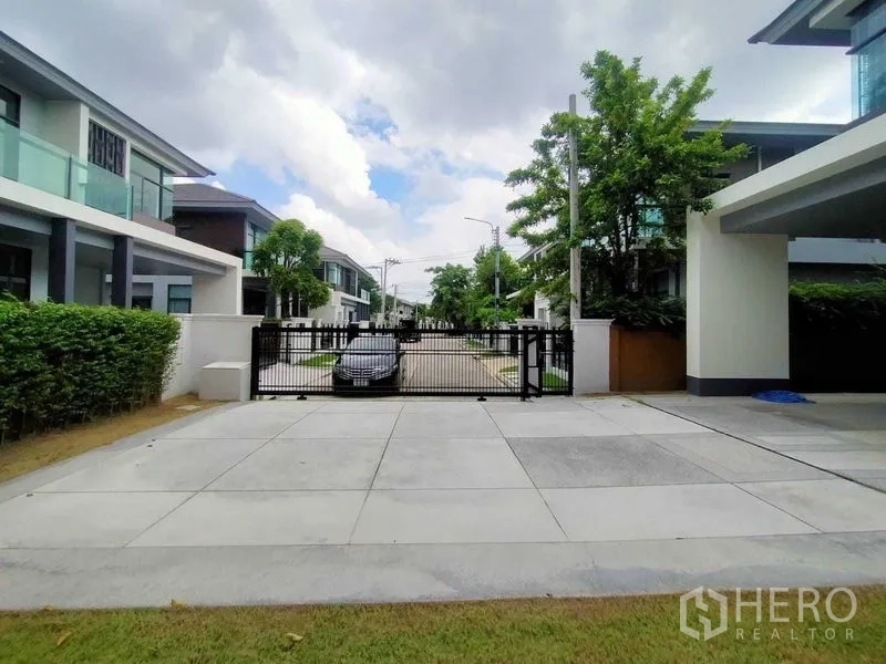 บ้าน ให้เช่าหรือขายในPrawet, Bangkok - ลานจอดรถพร้อมประตูรั้วสไลด์ มองเห็นถนนในโครงการที่เงียบสงบ