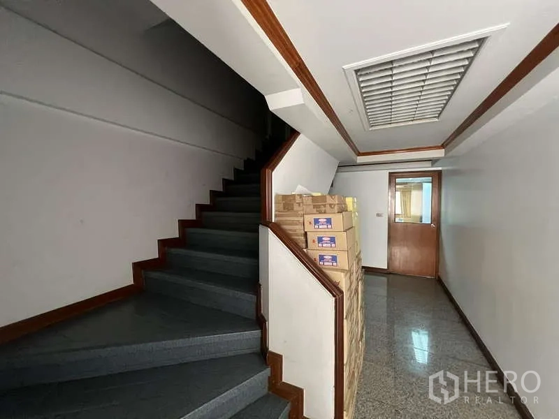 Office Space for rent - Interior staircase and corridor with boxes and office door.
