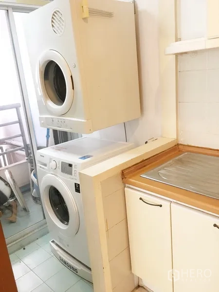 公寓 出租在Pathum Wan, Bangkok - 洗衣区，叠放式洗衣机和烘干机，靠近阳台门。