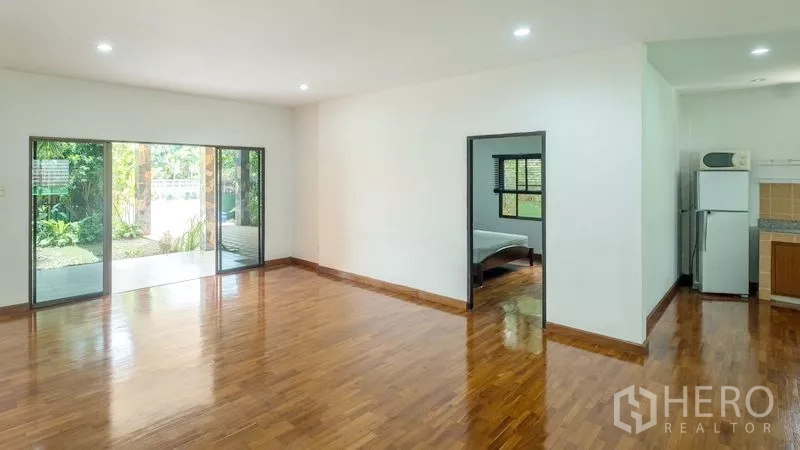 Detached House for sale in Bang Lamung, Chon Buri - Bright living room with sliding glass doors opening to a covered patio and garden views.