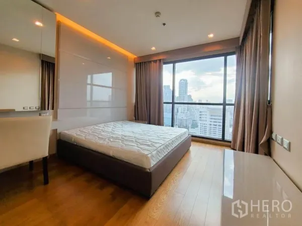 公寓 出租在Bang Rak, Bangkok - 高楼层卧室，木地板与落地窗，俯瞰曼谷天际线。