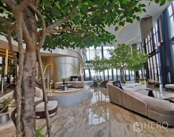 公寓 出租 - 豪华空中会所大堂，室内绿植、云石地面与落地窗俯瞰曼谷。