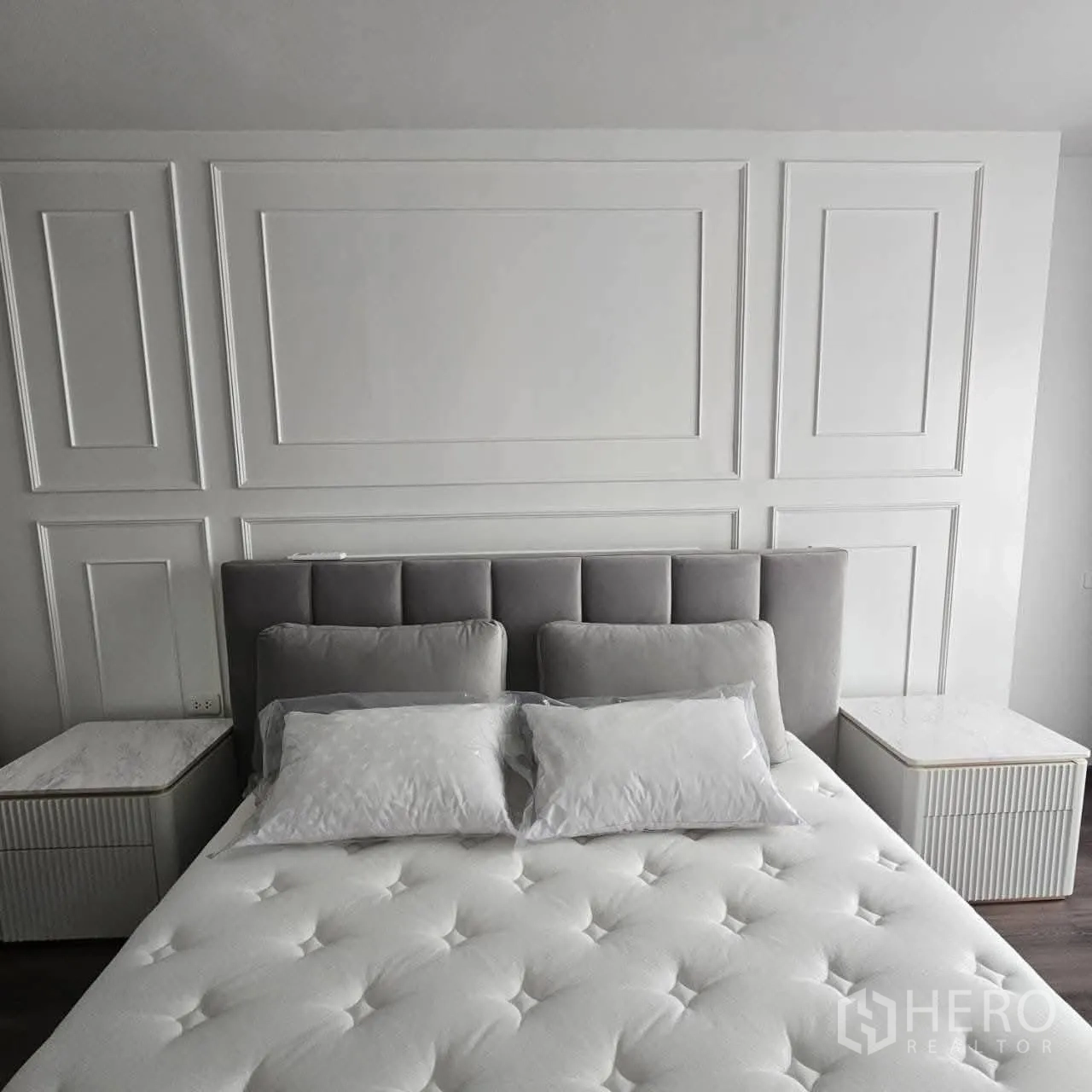 公寓 for rent in Huai Khwang, Bangkok - 主卧配软包床头、白色线条墙和成套床头柜。
