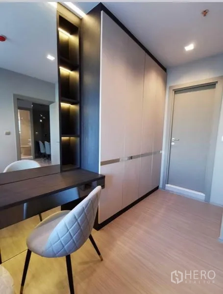 Condominium for rent in Huai Khwang, Bangkok - Entry corridor featuring built-in wardrobe, vanity desk, and upholstered chair