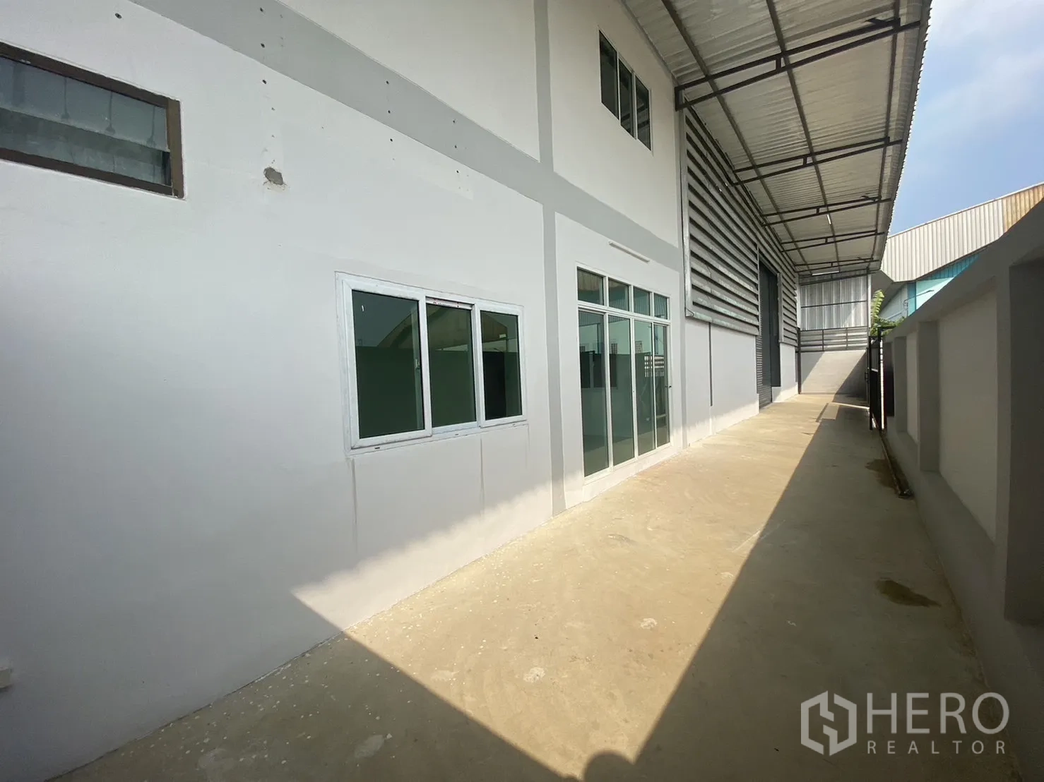 โรงงาน for rent or sale in Mueang Samut Sakhon, Samut Sakhon - ด้านข้างตัวอาคารมีสำนักงานกระจกและหน้าต่าง ใต้กันสาดเมทัลชีท