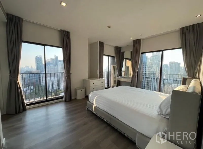 คอนโด ให้เช่าในBangkok - ห้องนอนมุมพร้อมประตูกระจกหลายด้านออกสู่ระเบียง โต๊ะเครื่องแป้ง และวิวพาโนรามา