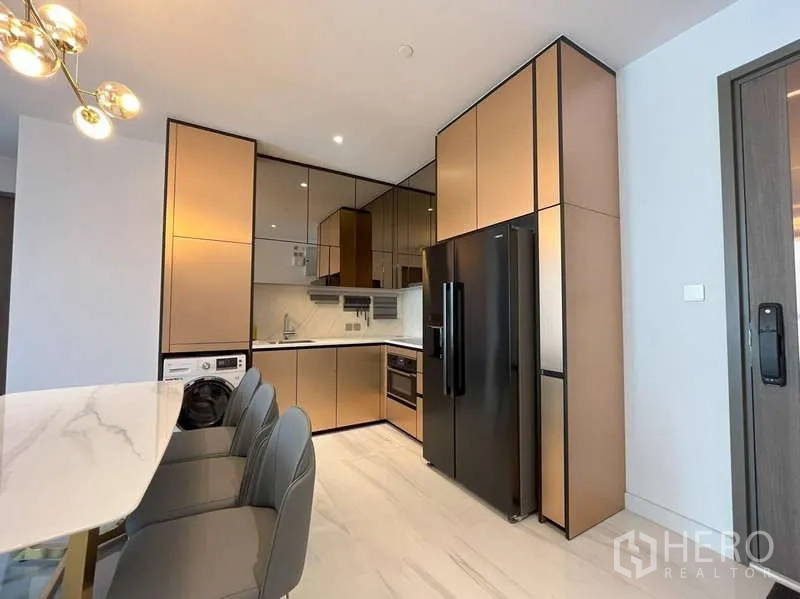 คอนโด ให้เช่าหรือขายในSathon, Bangkok - ครัวรูปตัวแอลทันสมัย ตู้บิลท์อินตัดดำ ตู้เย็นประตูคู่ และเครื่องซักผ้า