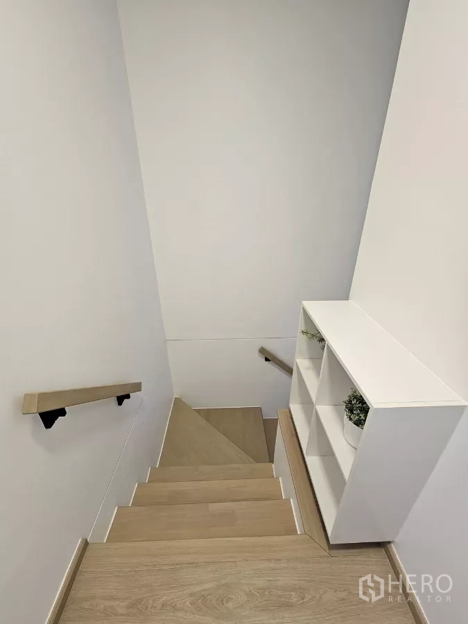 Townhouse for rent in Bang Phli, Samut Prakan - Wood staircase with handrails and white shelving at the landing