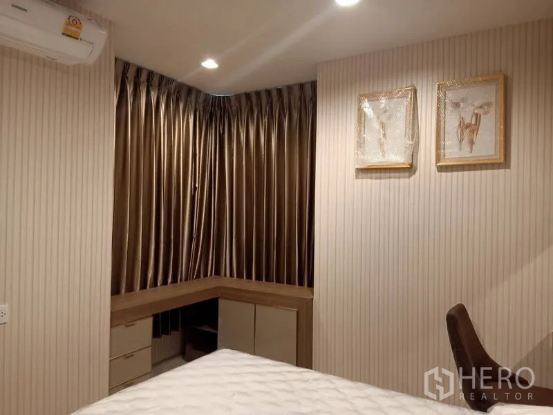 Condominium for rent in Pathum Wan, Bangkok - Cozy bedroom with L-shaped desk, gold curtains and built-in storage.